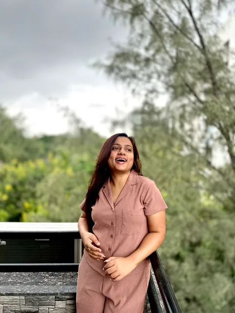 Laughing on a balcony, trees behind