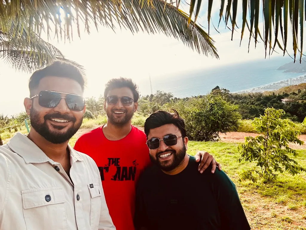 Three friends by the sea under palm leaves