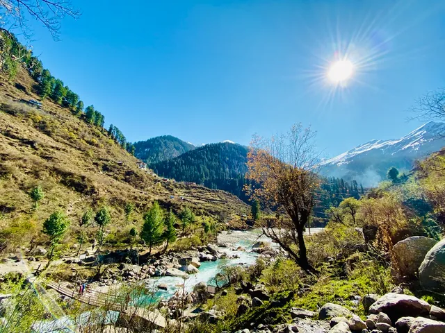 A river valley with the sun above the hills